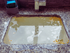 sink filled with dirty water because of stubborn clog