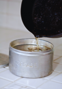 Homeowner pouring grease into a container