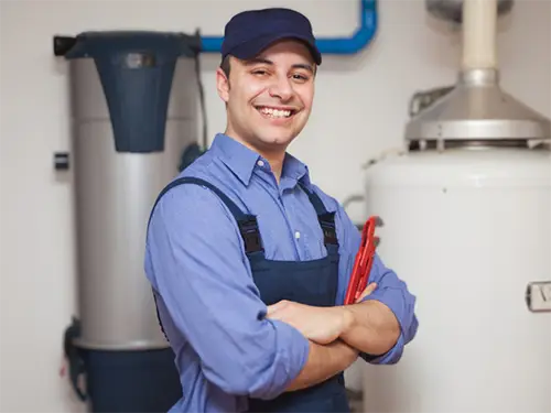 Professional plumber standing by water heater system ready for installation services