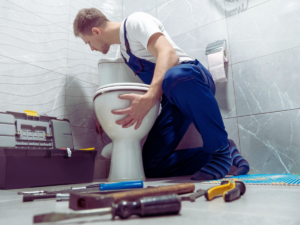 Plumber fixing leaking toilet