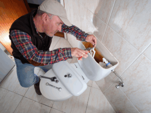 Plumber repairing toilet 